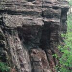 The Great Unconformity in western North America. Precambrian sedimentary layers formed in the ocean, hardened into rock on land, then were tiled sixty degrees. Once again submerged in the sea, new horizontal layers accumulated (still Precambrian) on the top of the tilted layers. Over a billion years of Earth history is missing at the point of contact in this unconformity. Here seen in the Black Hills National Forest of South Dakota.
