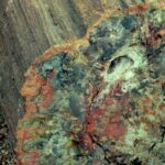Petrified stump, about 260 million years old. Colors come from minerals, primarily iron, that diffused into the wood as it slowly decomposed. This specimen shows both the longitudinal (wood grain) and cross section. Petrified Forest National Park, Arizona.