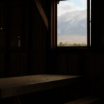 The Manzanar detention facility housed American citizens of Japanese descent during World War Two. They were treated kindly but had no rights. The facility fell into disrepair after the war but has recently been reconstructed. It was in the rain shadow desert east of the Sierra Nevada in California, as seen through the window.