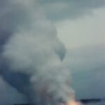 Lava flows from Kilauea volcano in Hawaii to the sea in 1997. Glowing lava and steam.